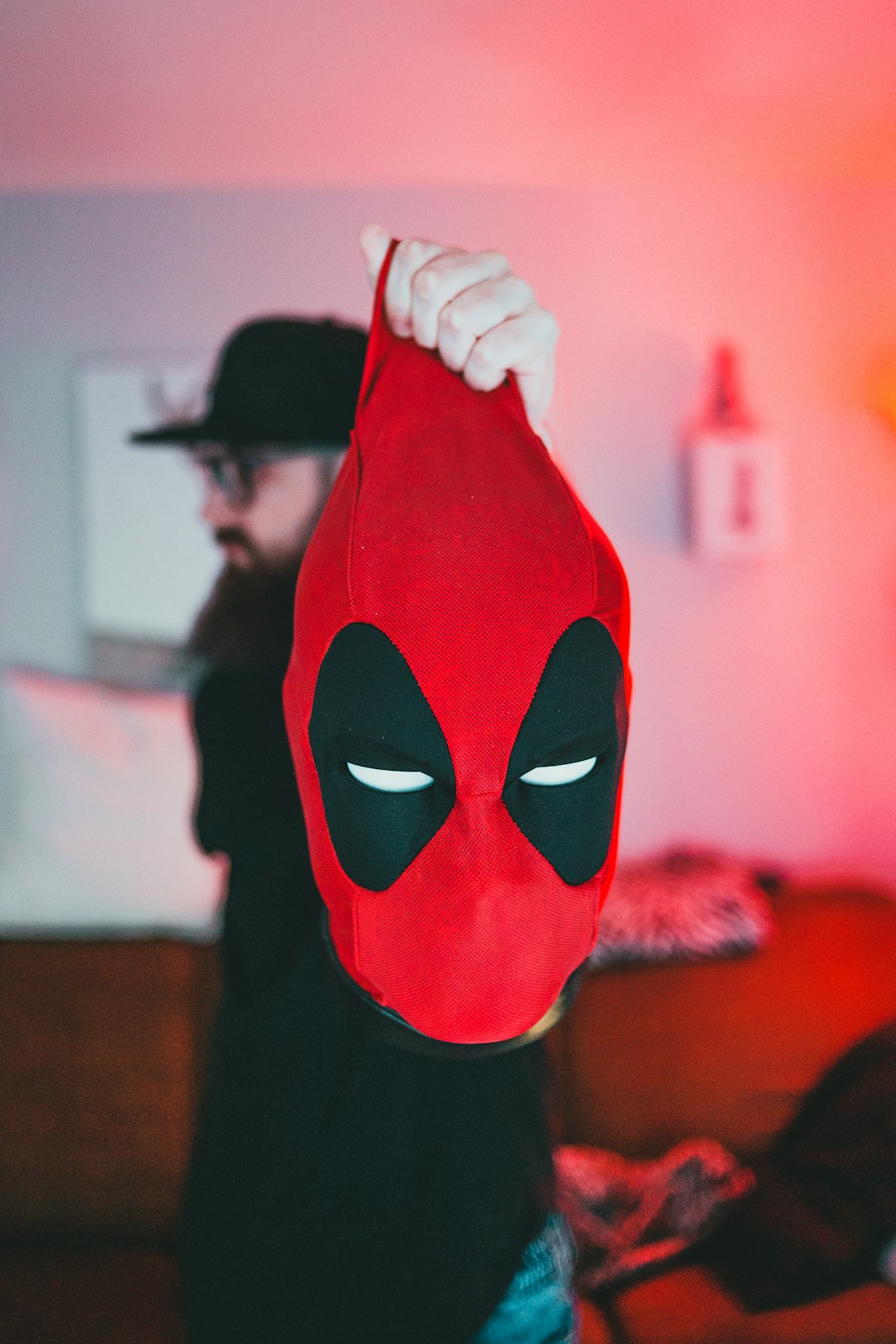 person holding red and black spider man mask