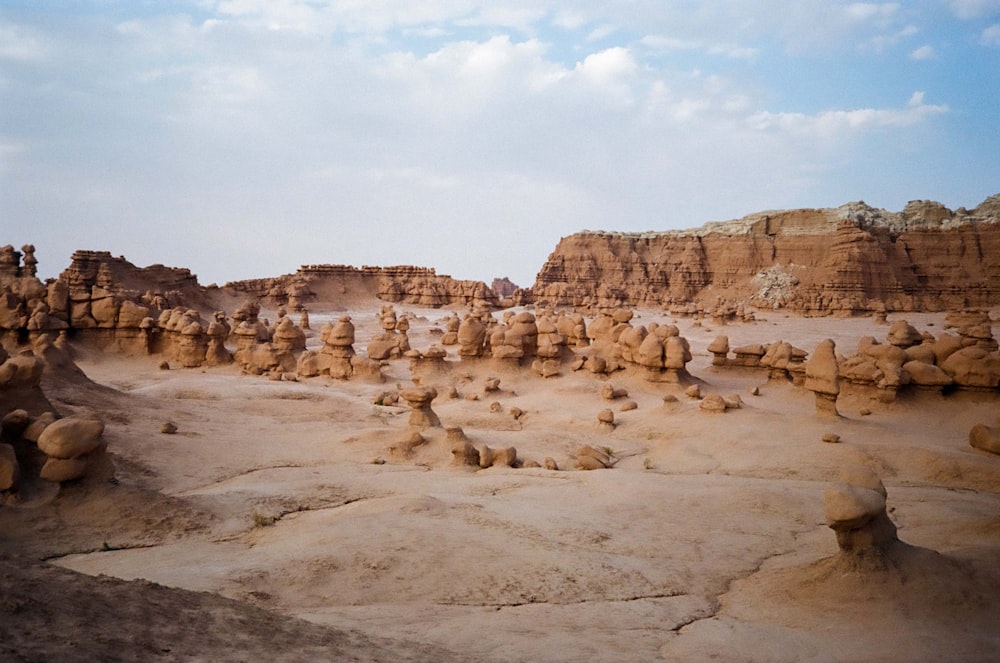 brown rock formation under white clouds during daytime