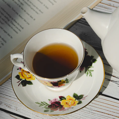 white ceramic teacup on white and pink floral ceramic saucer