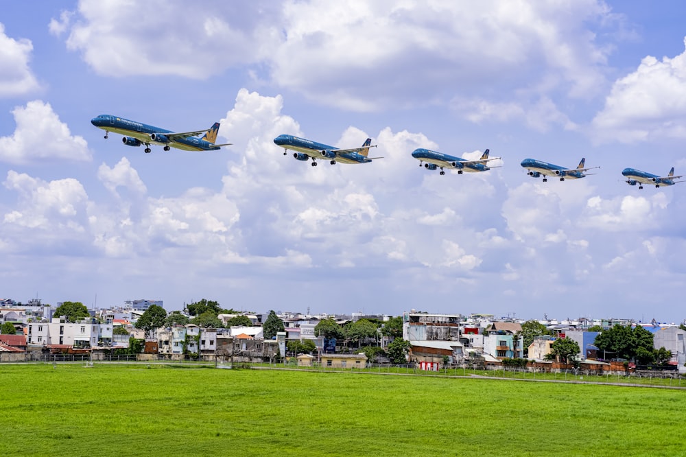 blue and white airplane flying over green grass field during daytime