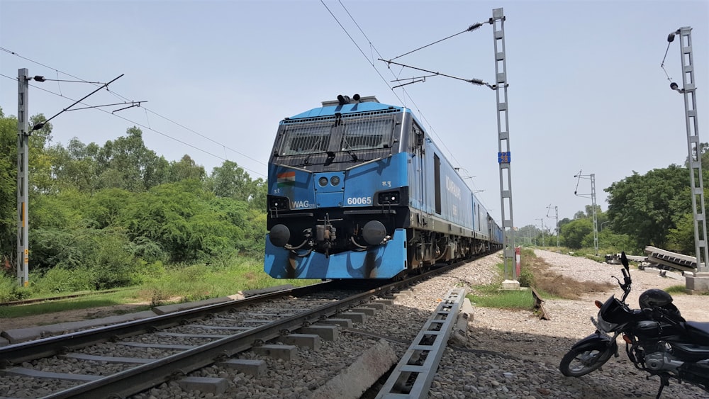 blue and black train on rail tracks during daytime