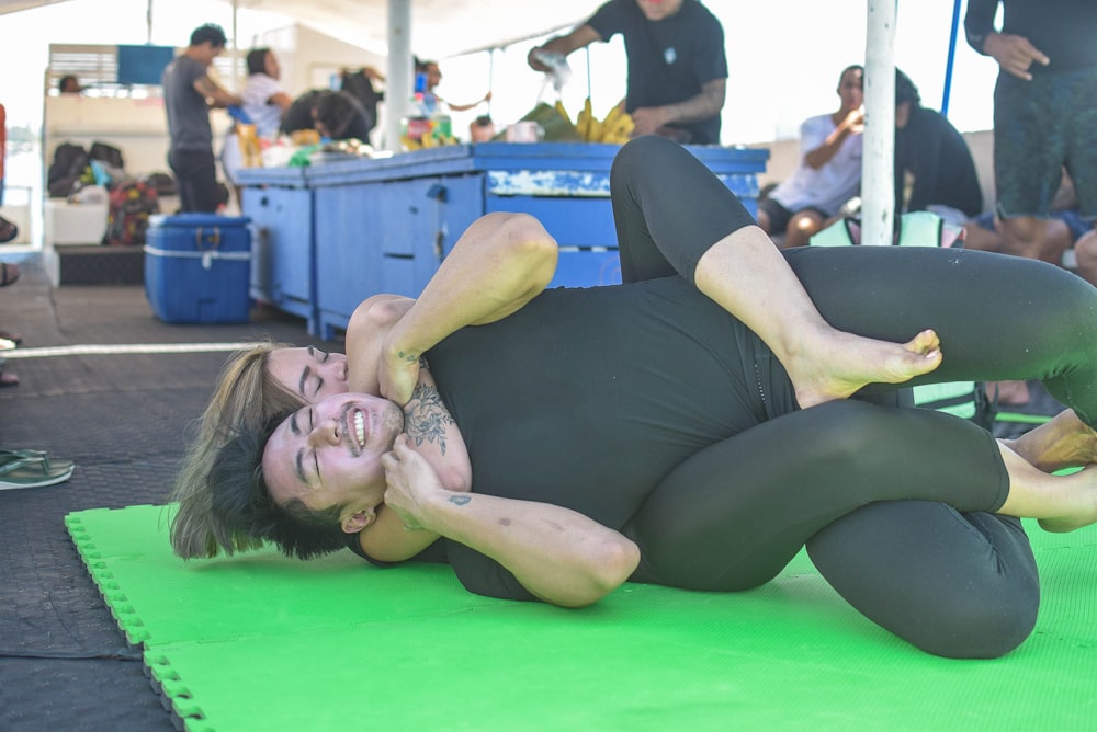 woman in black tank top lying on green floor