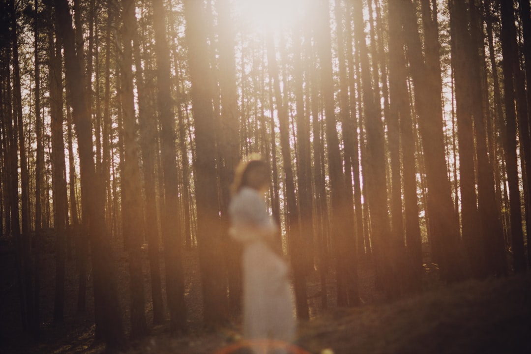 woman in white dress standing on forest during daytime