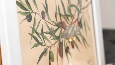 Close-up of a Casa Aurelia digital art print showing delicate olive branches and warm earth tones.