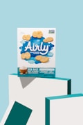 A brightly colored image featuring a box of Airly sea salt oat clouds snack crackers prominently displayed against a pastel blue background. The packaging design includes whimsical cloud imagery and a logo emphasizing climate-friendly snacking. Several oat crackers are shown around the box.