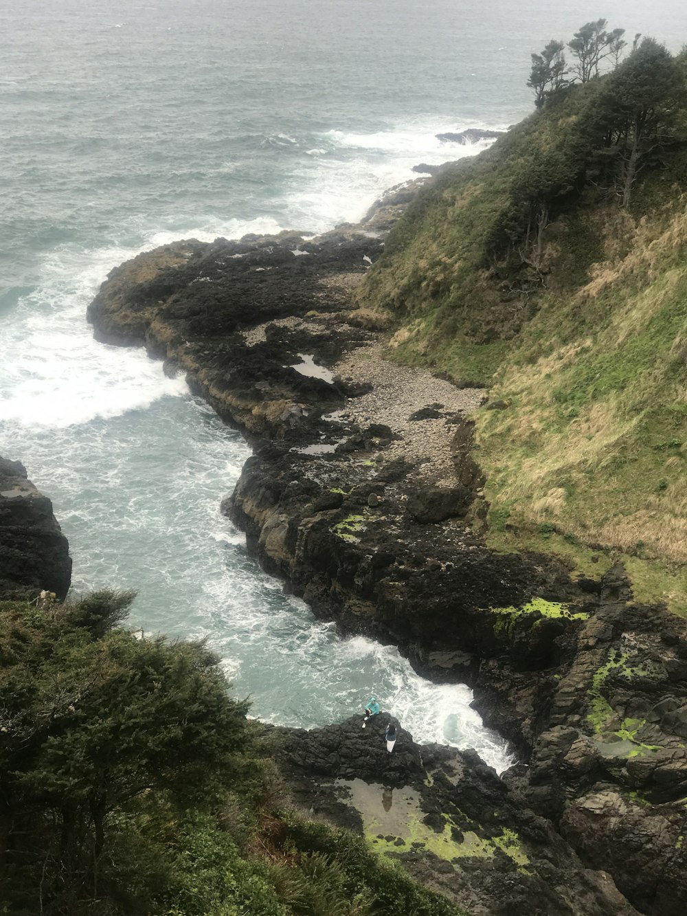 green and brown rock formation beside blue sea during daytime