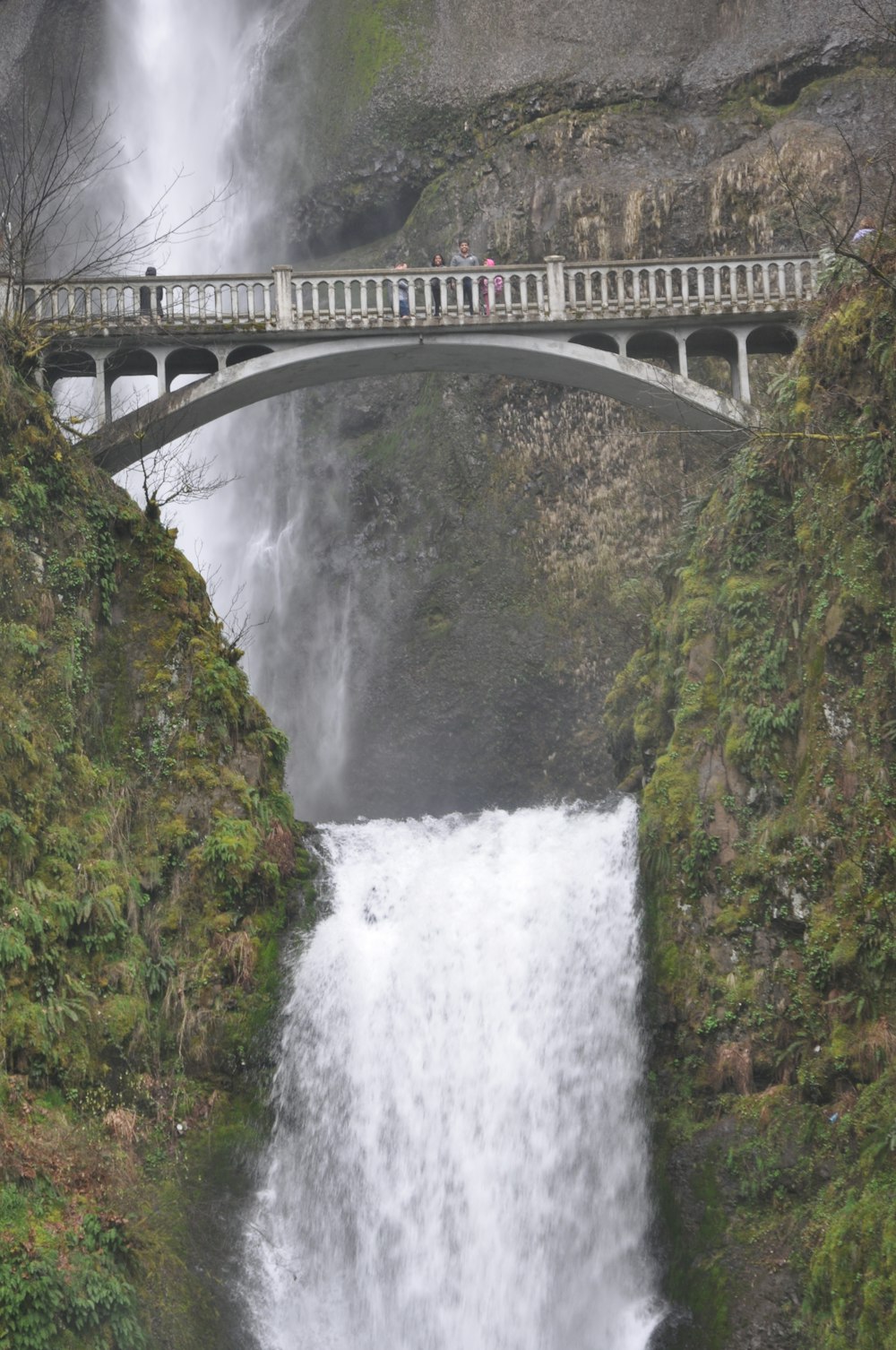 waterfalls under gray concrete bridge during daytime