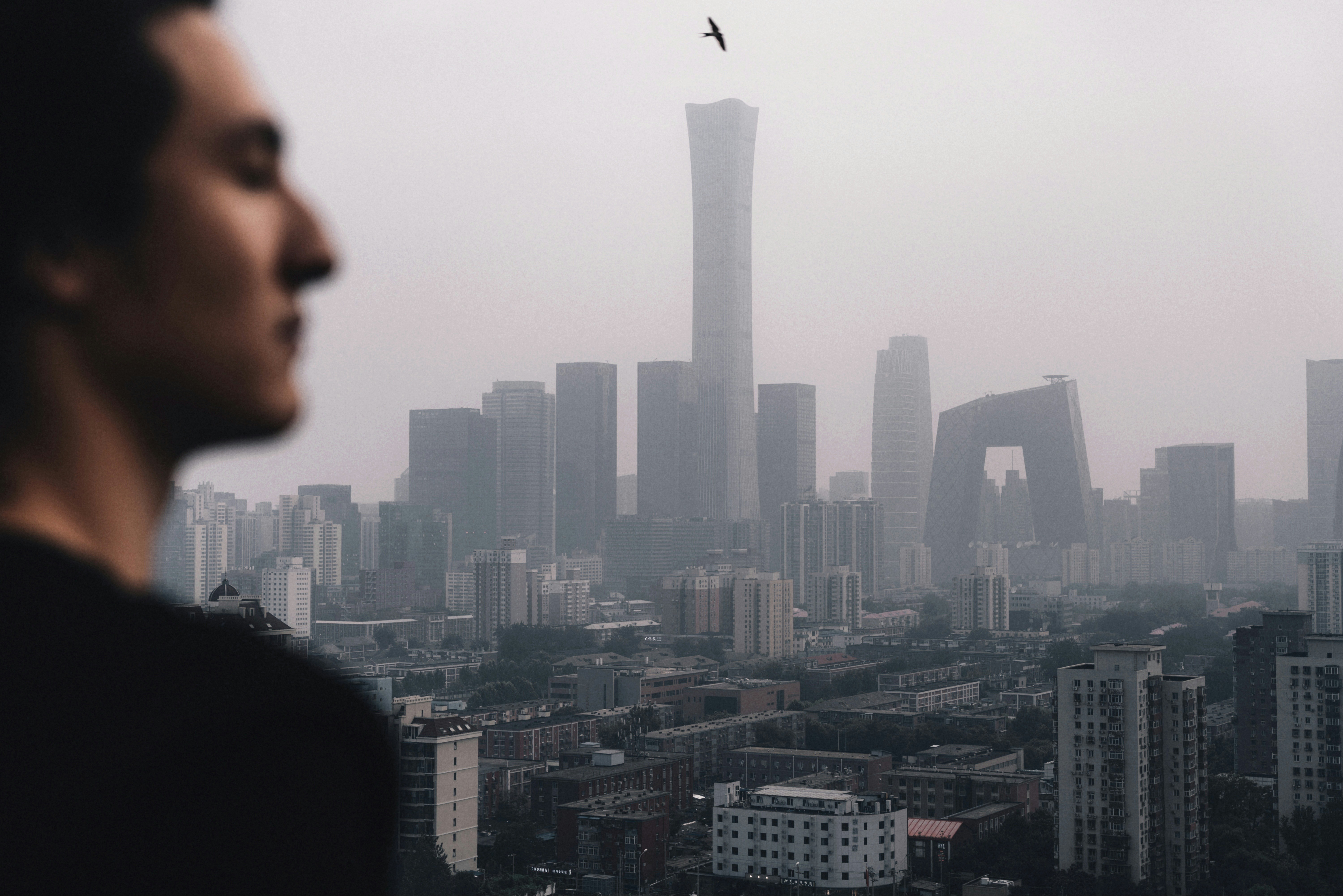 man taking selfie near city buildings during daytime