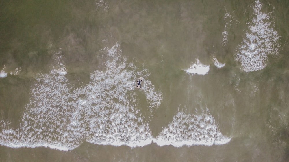 person surfing on sea waves during daytime