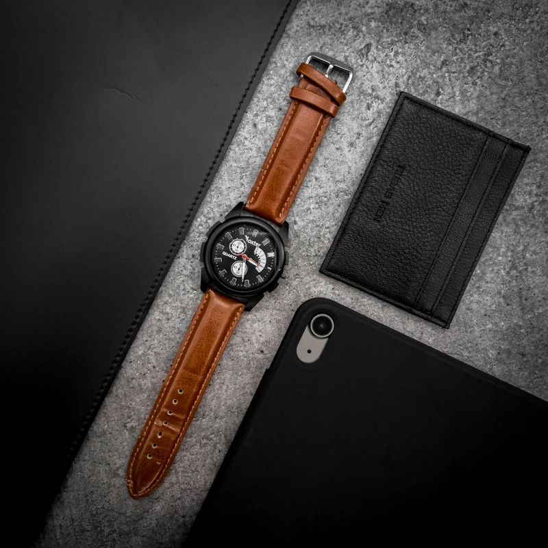 Silver analog watch with a brown leather strap