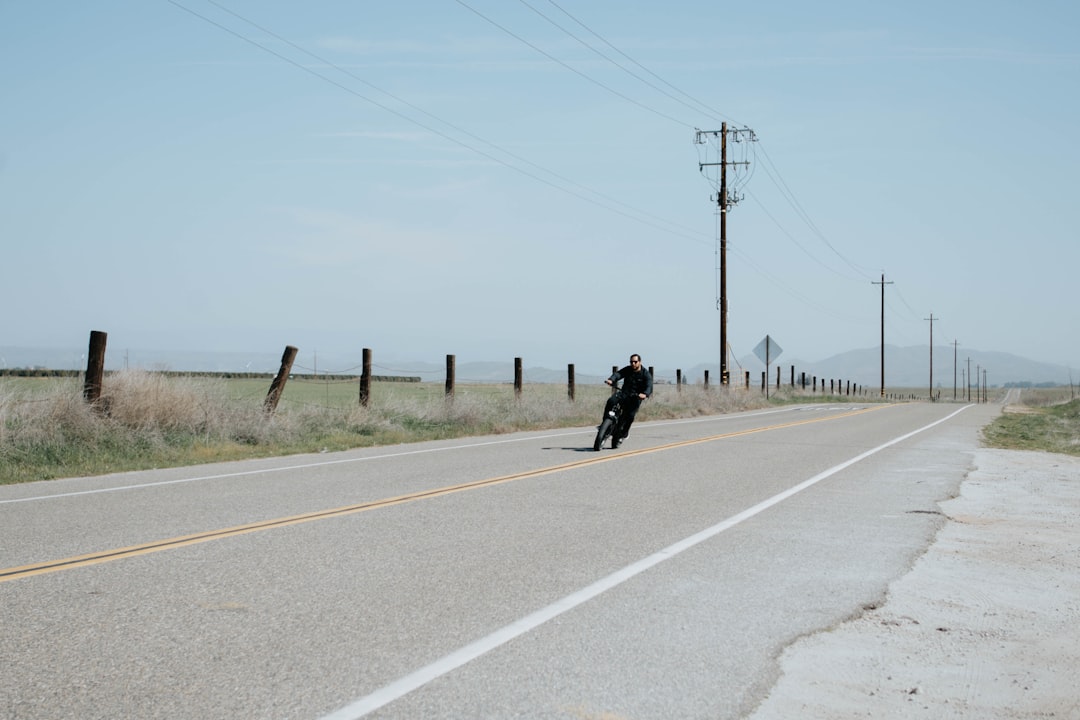 man in black jacket and black pants walking on gray concrete road during daytime