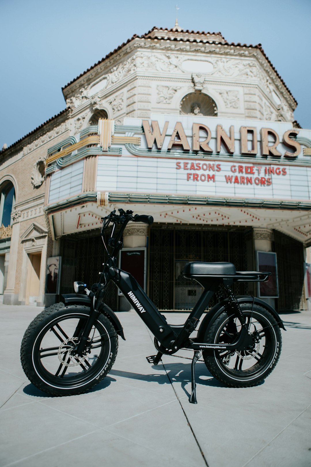 black motorcycle parked beside brown concrete building