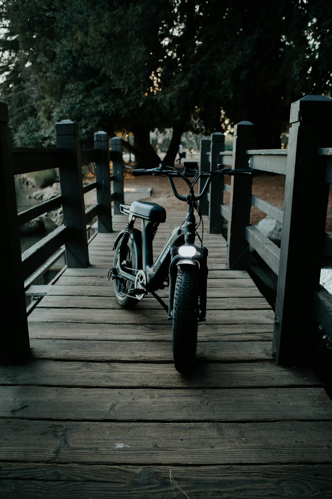 black motorcycle parked beside wooden fence