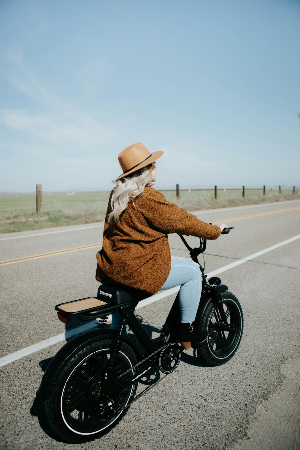 man in brown jacket riding motorcycle on road during daytime