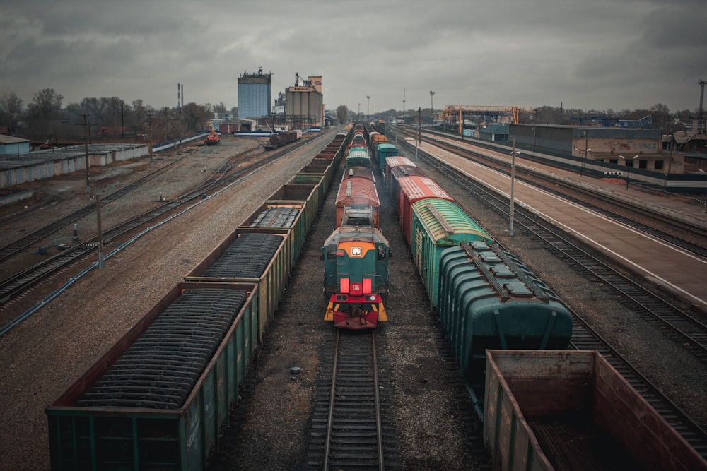 green and red train on rail tracks during daytime