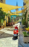 red motor scooter parked near yellow and blue concrete building during daytime