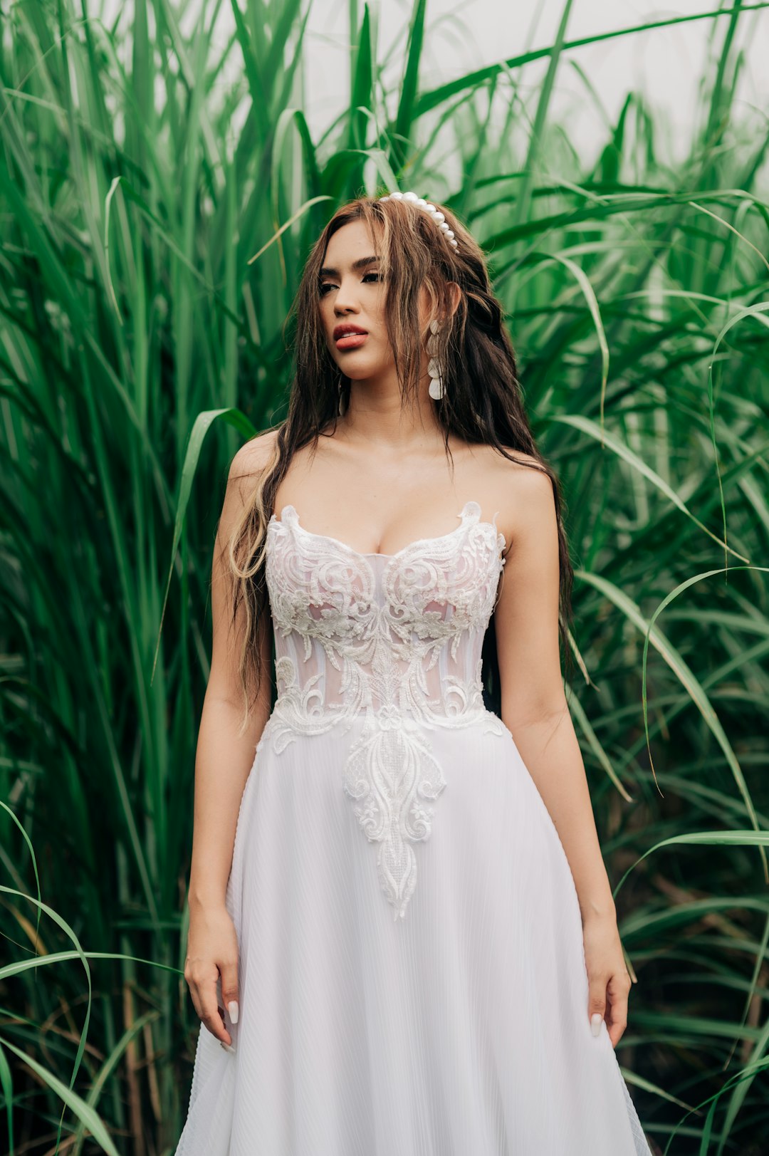 woman in white floral dress standing near green plants during daytime