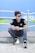 man in black and white stripe polo shirt and blue denim jeans sitting on concrete floor
