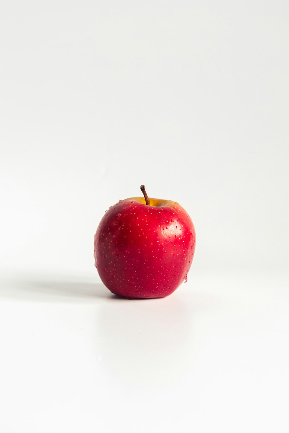 mela rossa su superficie bianca