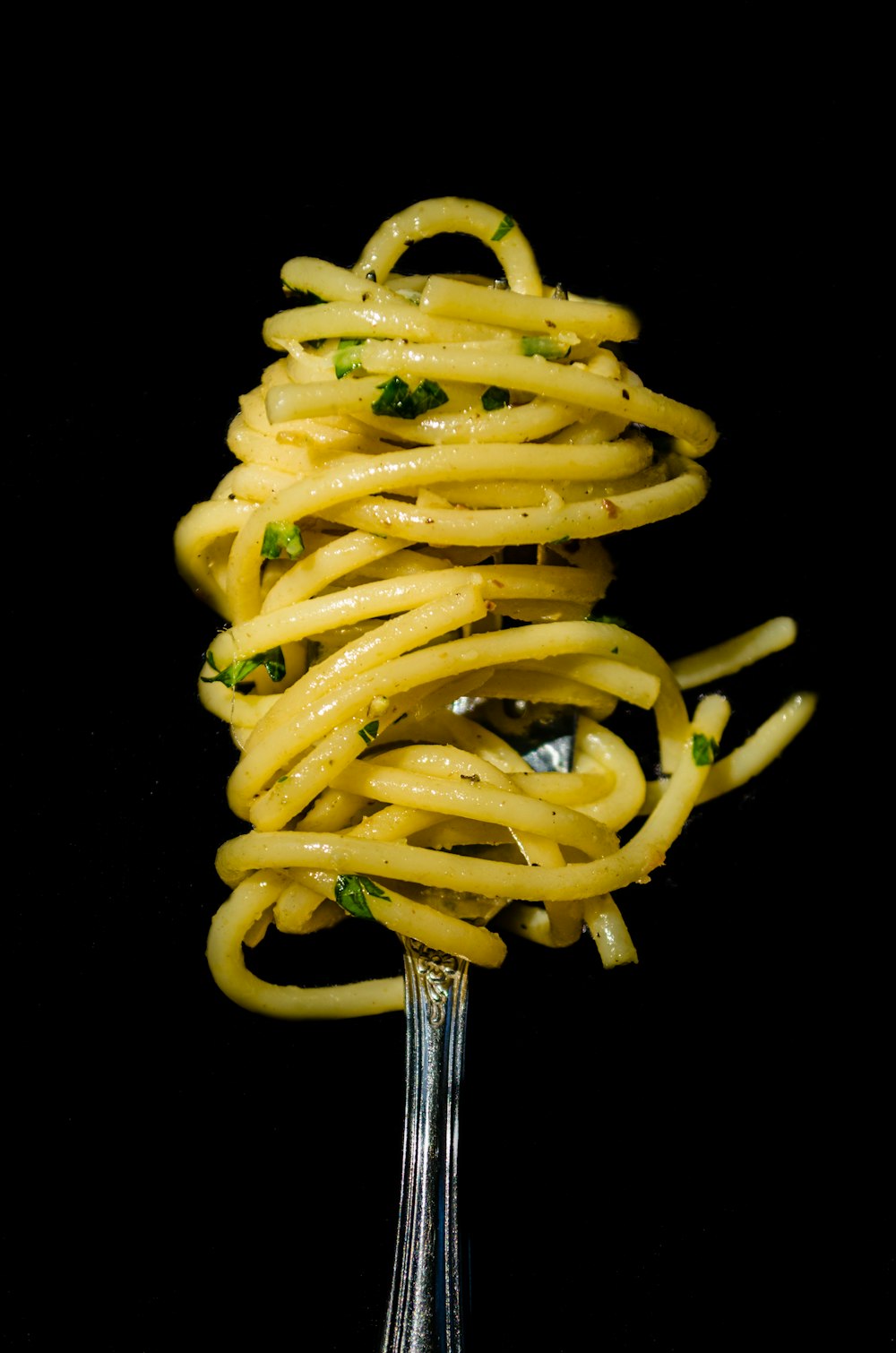 Pasta mit grüner Soße auf schwarzem Hintergrund