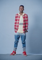 man in red and white plaid dress shirt and blue denim jeans
