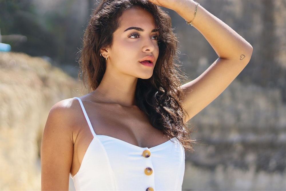 woman in white tank top holding her hair