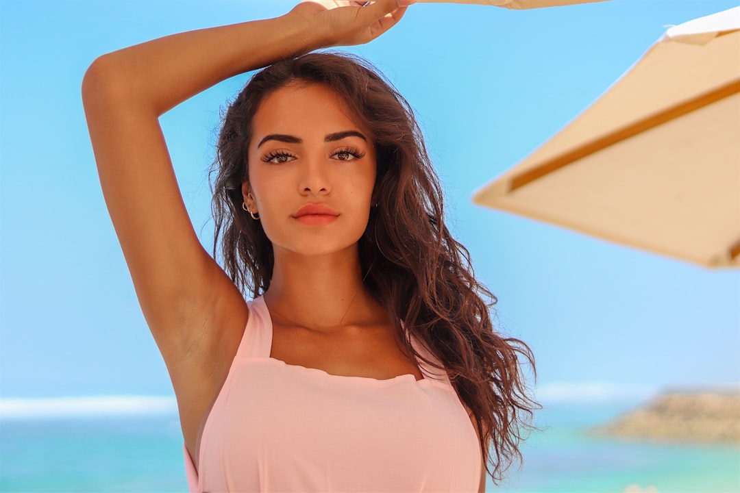 Girl in a pink dress under the beach umbrella