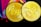 Two golden coins with the abbreviation 'EXU' engraved on them, surrounded by abstract colorful shapes in the background. The coins have detailed engravings, featuring animals and patterns along the edges.