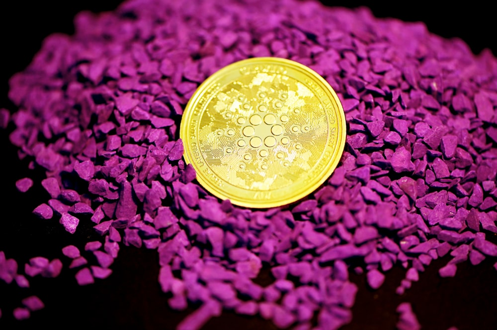 gold round coin on red textile