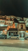 cars parked in front of brown concrete building during night time