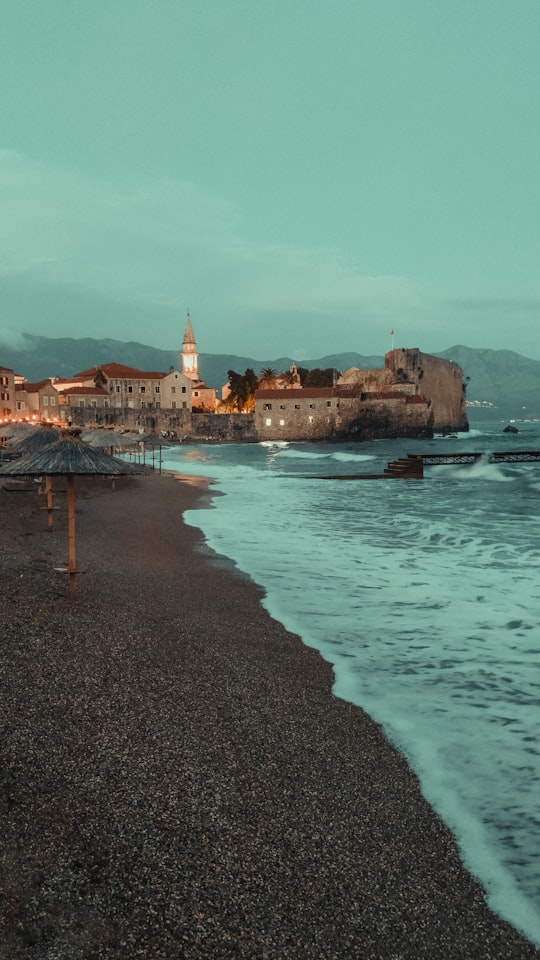 brown concrete building near body of water during daytime in Budva Old Town Montenegro