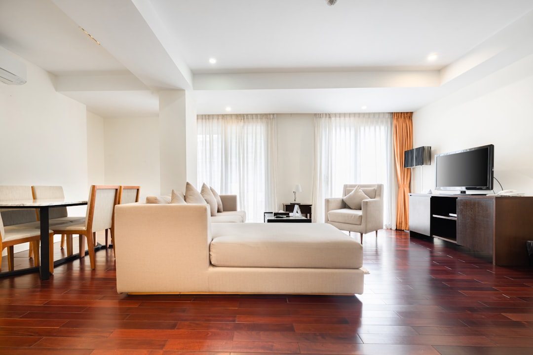 white sectional couch on brown wooden parquet flooring