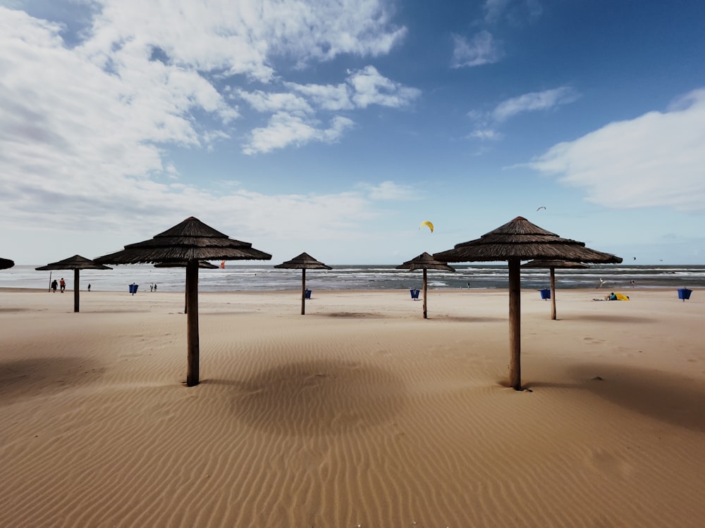 brown wooden beach lounge chairs on beach during daytime