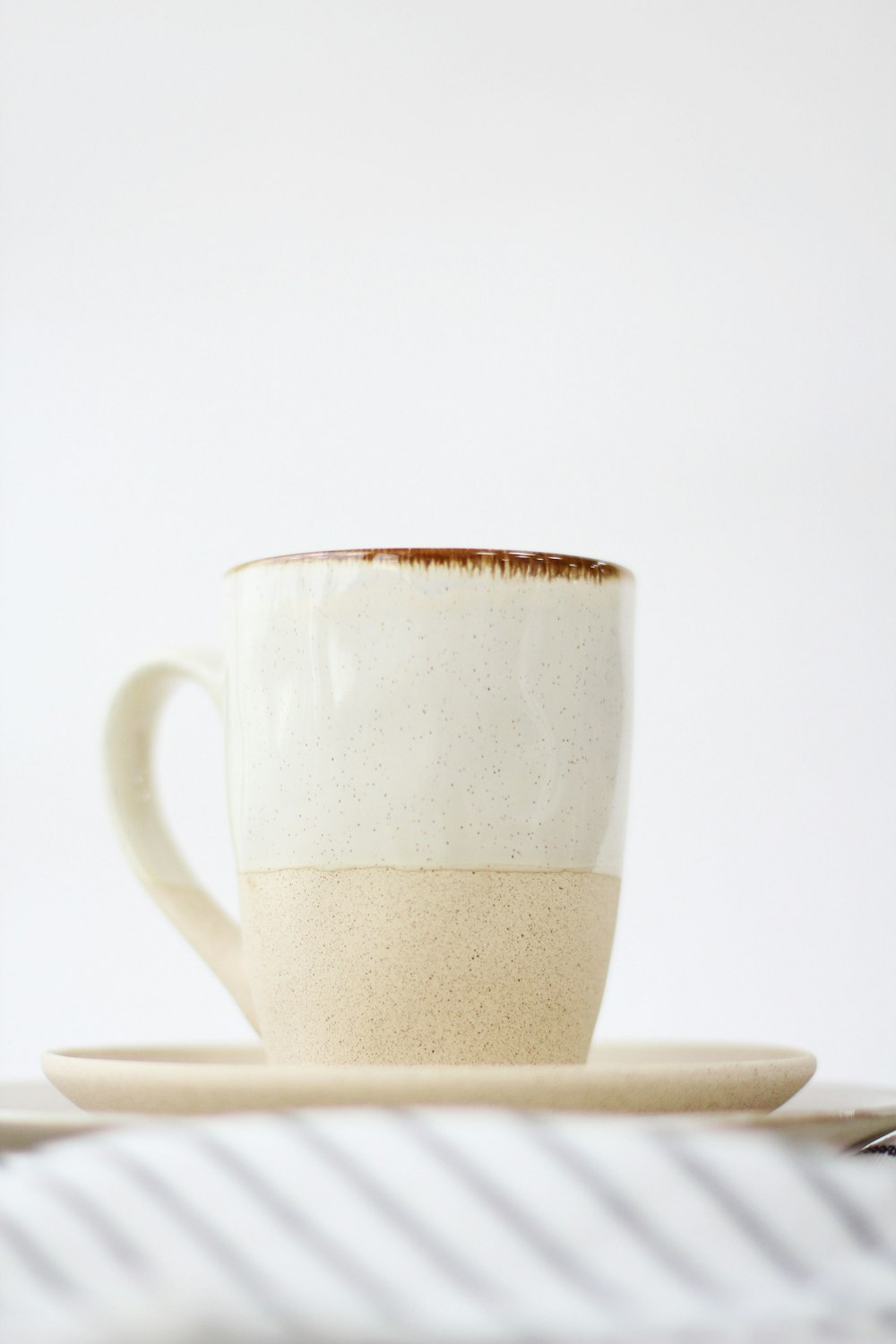 white ceramic mug on white table