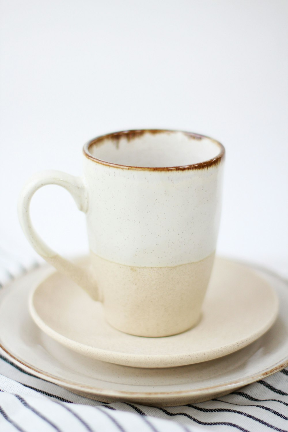 taza de cerámica blanca sobre platillo de cerámica blanca