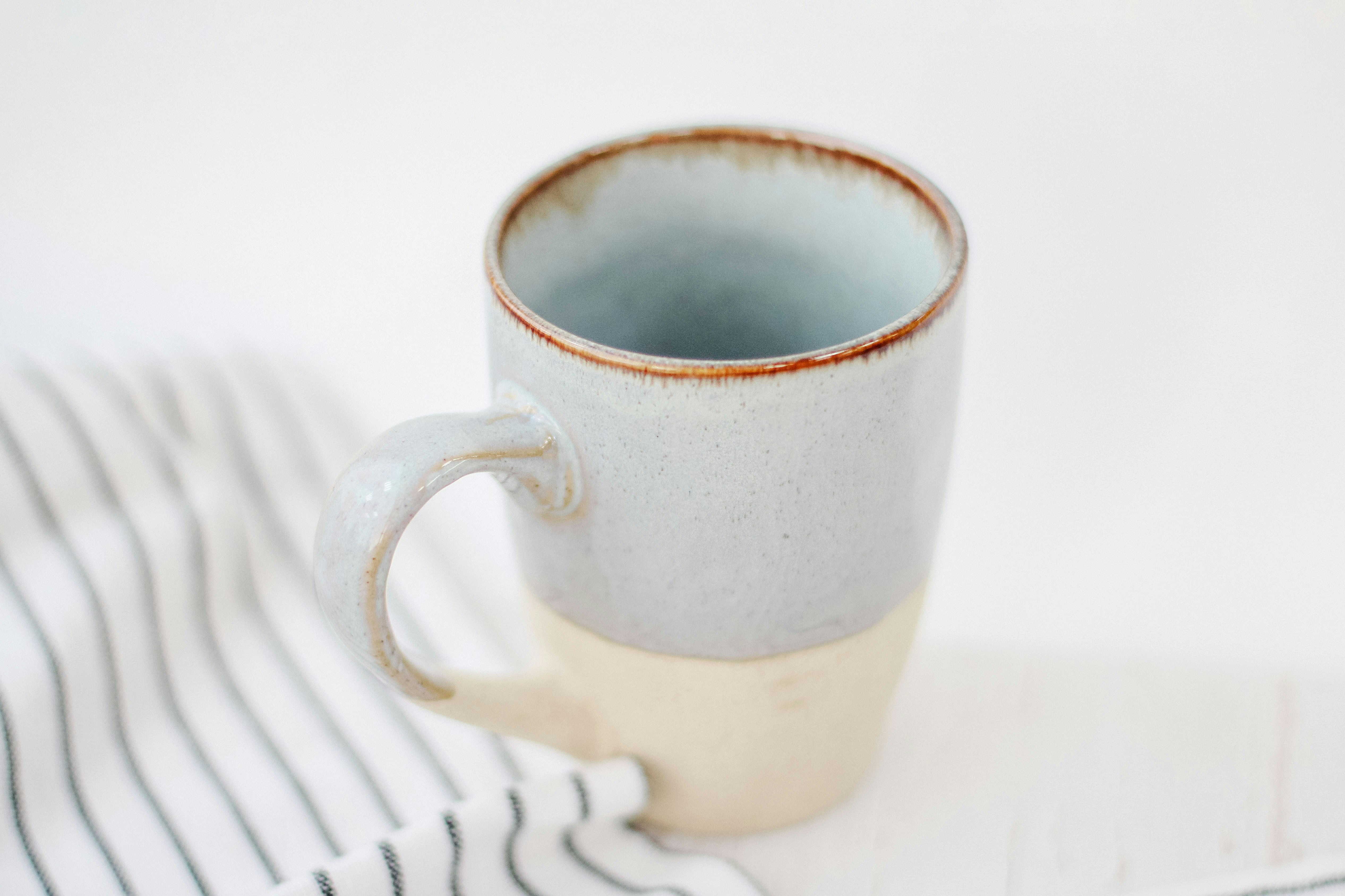 white ceramic mug on white table