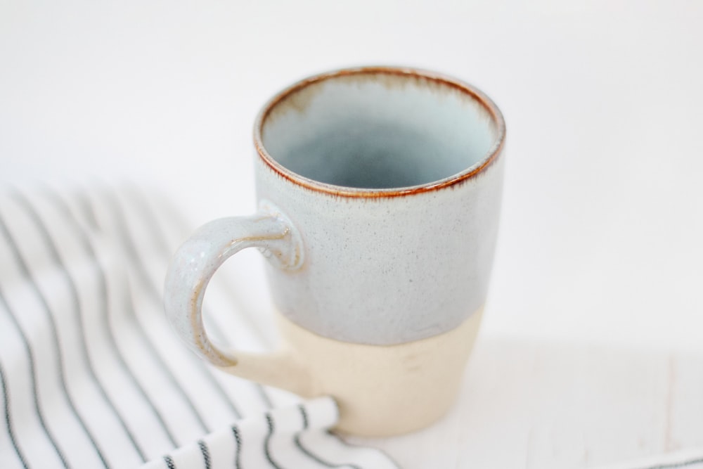 white ceramic mug on white table