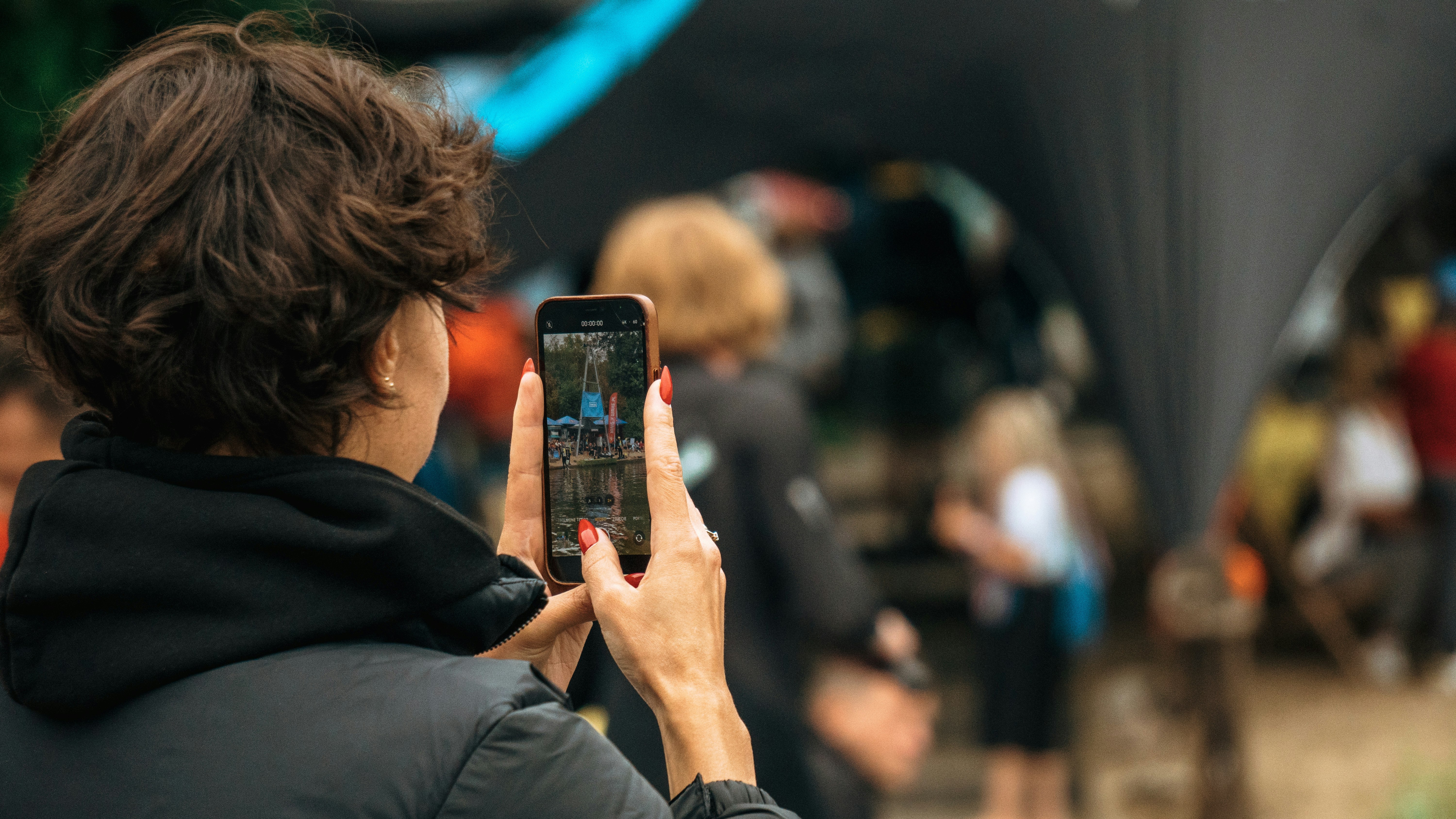 woman in black jacket holding black smartphone