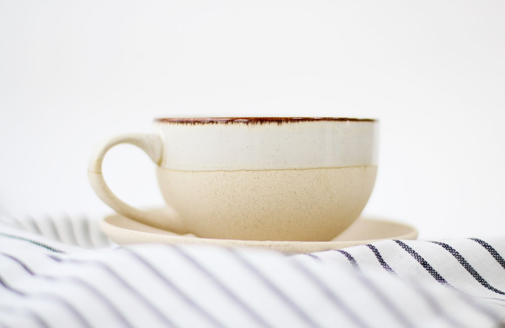 white ceramic teacup on white table