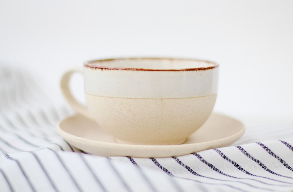 tasse à thé en céramique blanche sur soucoupe en céramique blanche