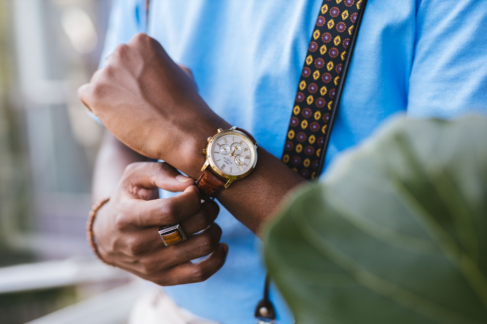 person wearing gold and silver round analog watch