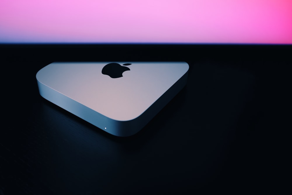 silver macbook on black table