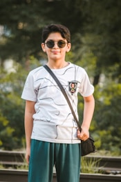 man in white crew neck t-shirt wearing black sunglasses