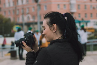 woman in black long sleeve shirt holding black dslr camera