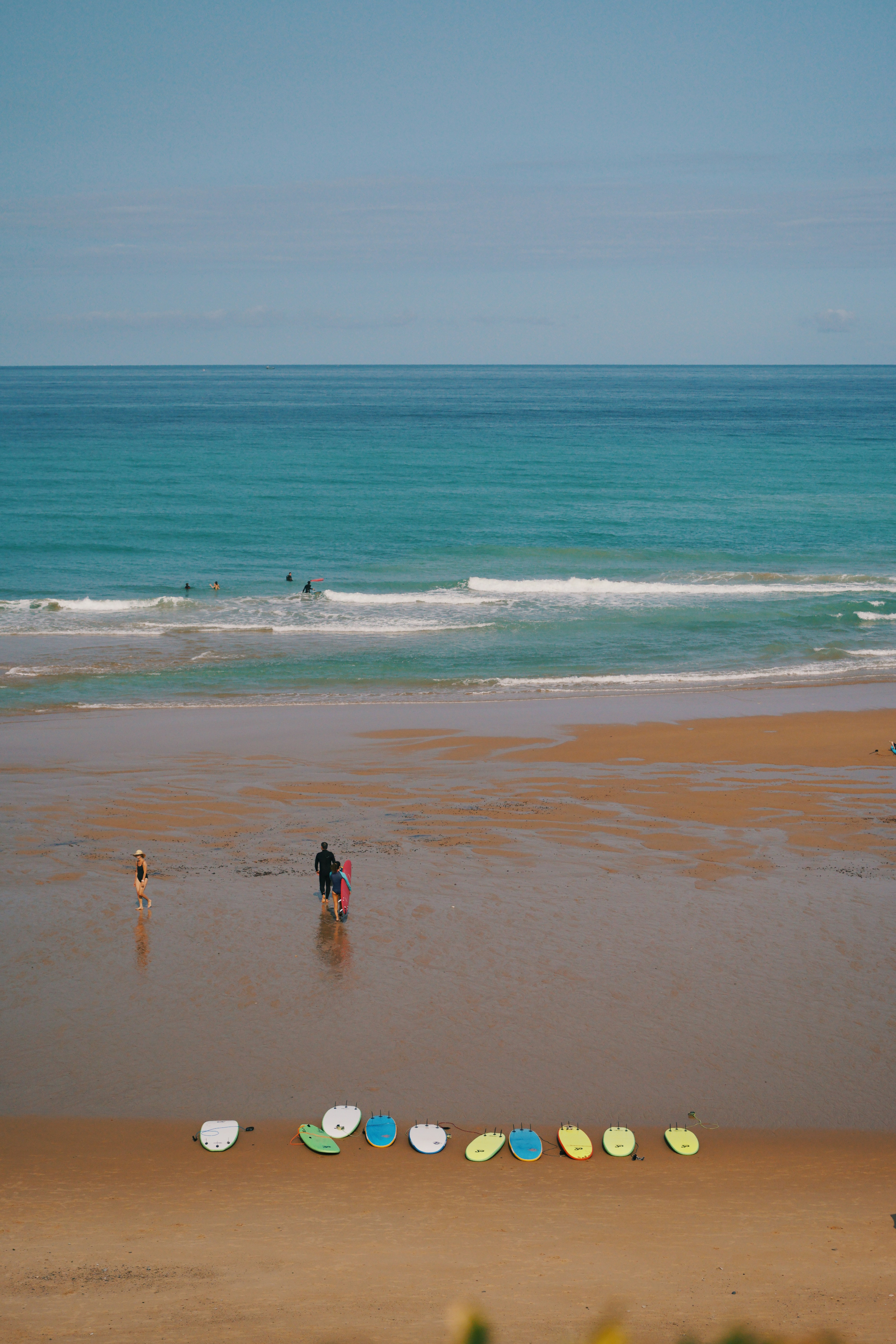 2 people walking on beach during daytime