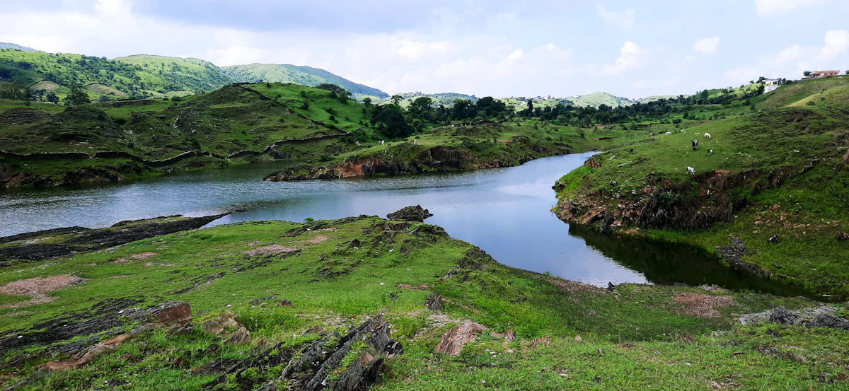 Green grass beside a lake under clouds