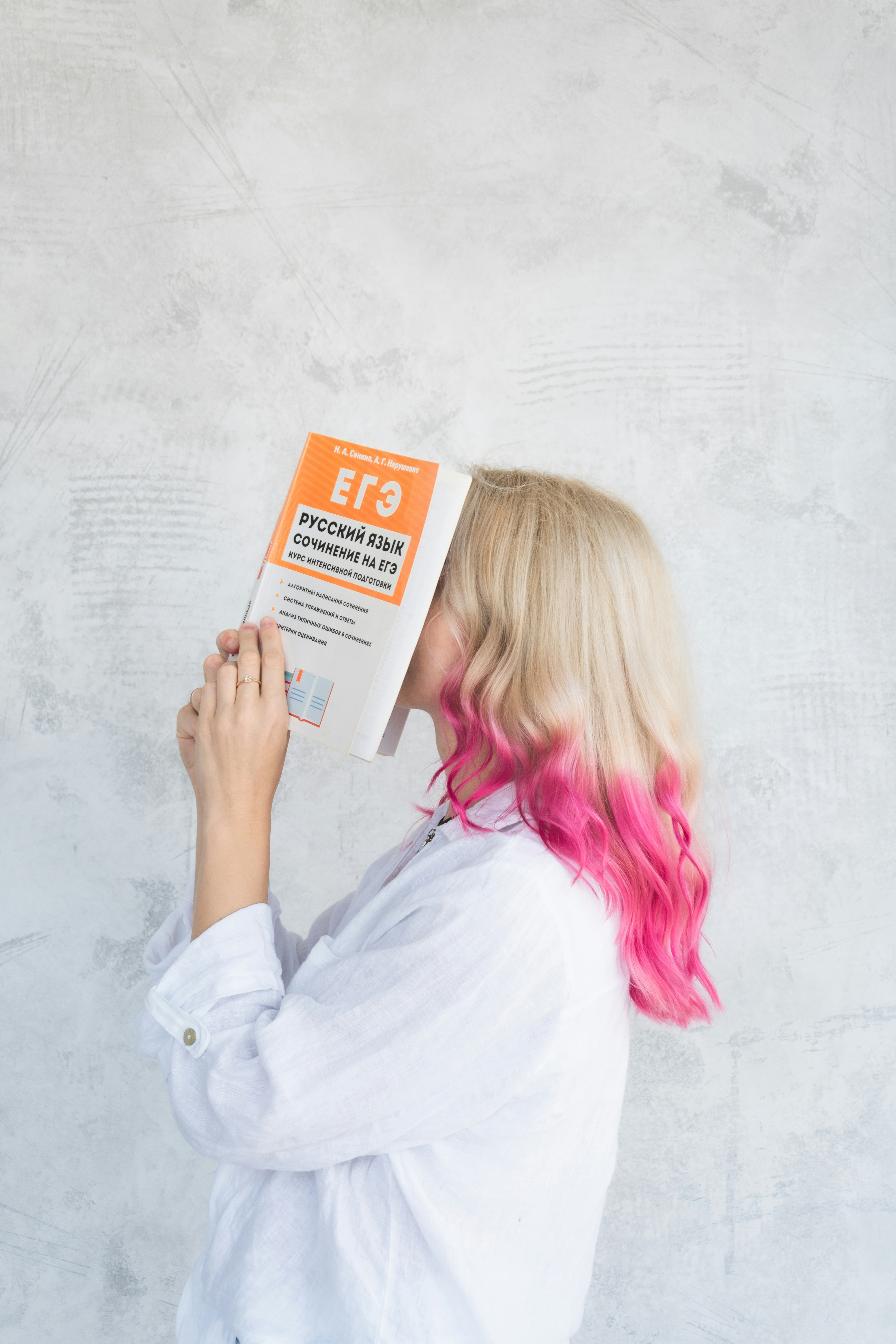 Woman with pink hair reading book