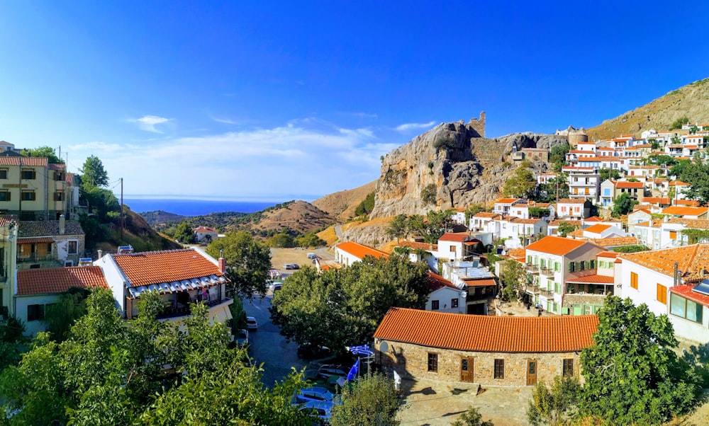 brown and white concrete houses near mountain under blue sky during daytime