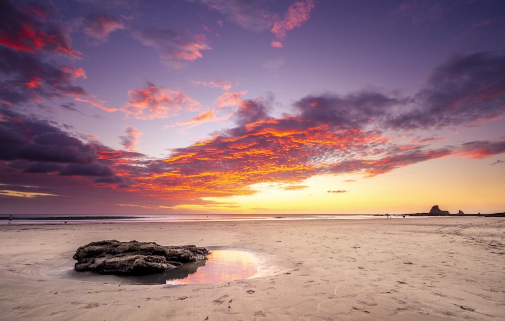 brown sand beach during sunset