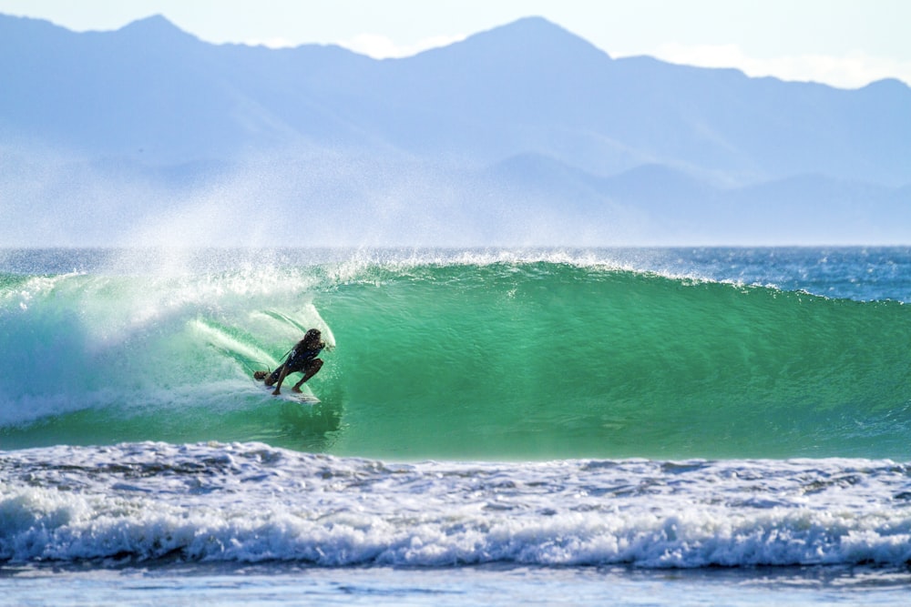 man surfing on sea waves during daytime